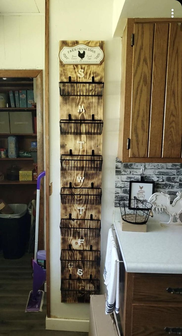 a kitchen with wooden cabinets and a wall hanging rack in the middle of the room