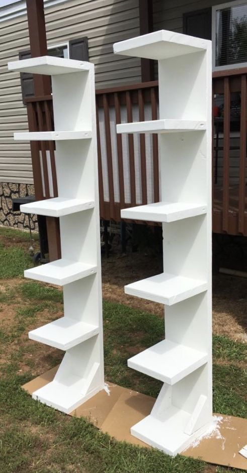 two white shelves sitting in the grass next to each other