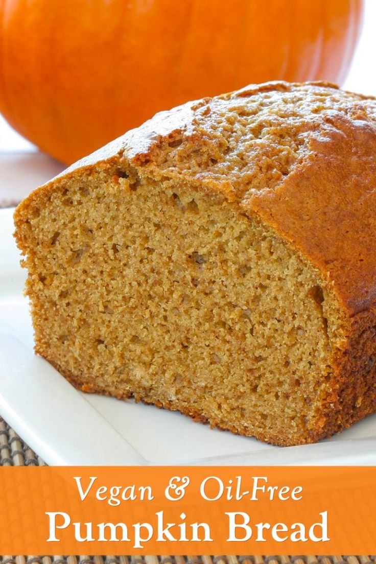 a loaf of vegan and oil - free pumpkin bread on a white plate with an orange pumpkin in the background