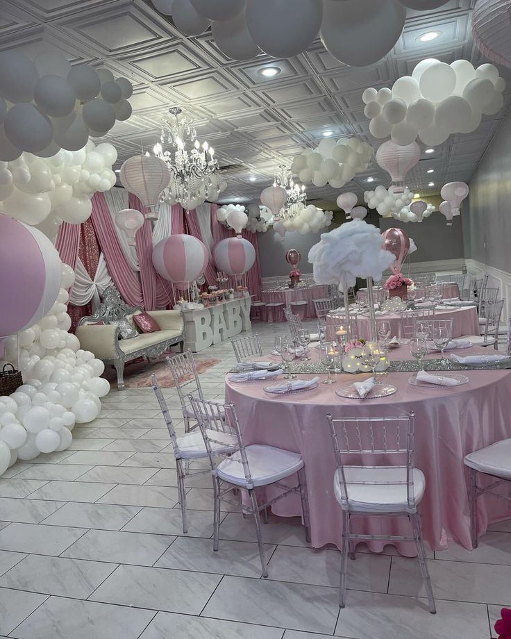 a room filled with lots of balloons and tables