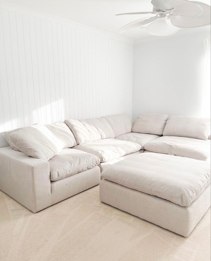 a large white sectional couch sitting in a living room