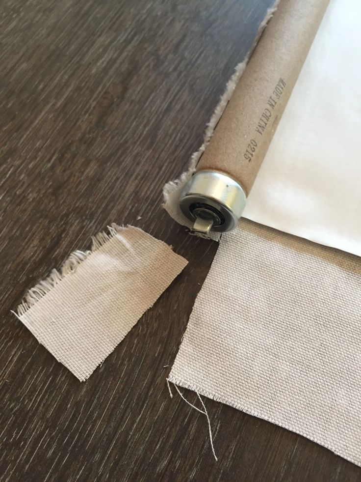 a roll of fabric is laying on the floor next to an empty piece of paper