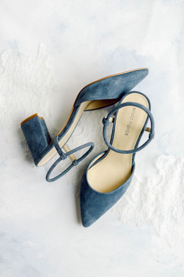 a pair of blue high heeled shoes sitting on top of snow