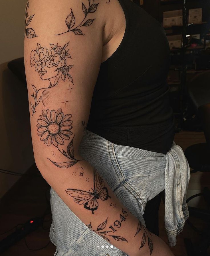 a woman's arm with flowers and butterflies on it