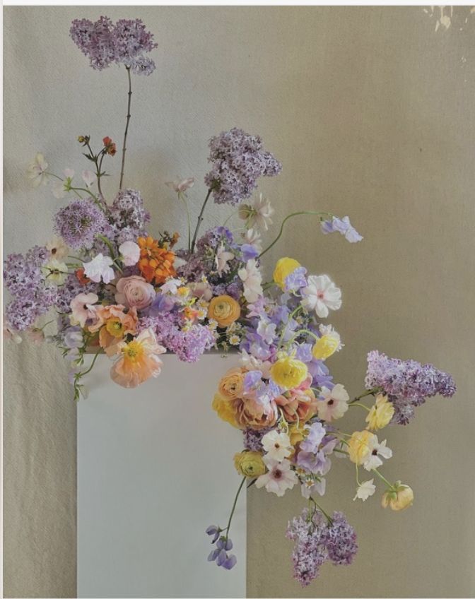 a white vase filled with lots of different colored flowers