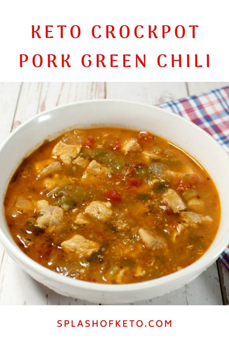 a white bowl filled with chicken and green chili soup on top of a wooden table