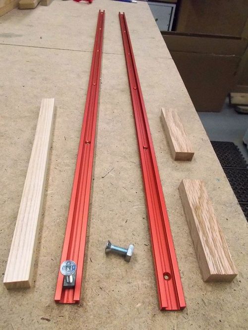 two pieces of wood sitting on top of a table next to screws and nuts