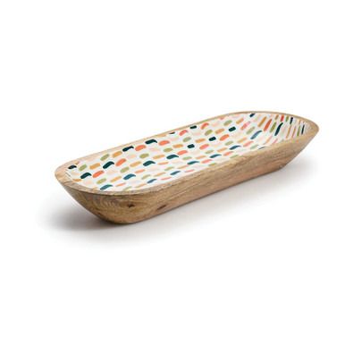 a wooden boat shaped dish with multicolored dots on the front and bottom, sitting on a white surface