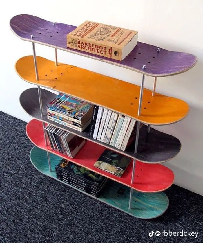 three skateboards are stacked on top of each other in front of a bookshelf