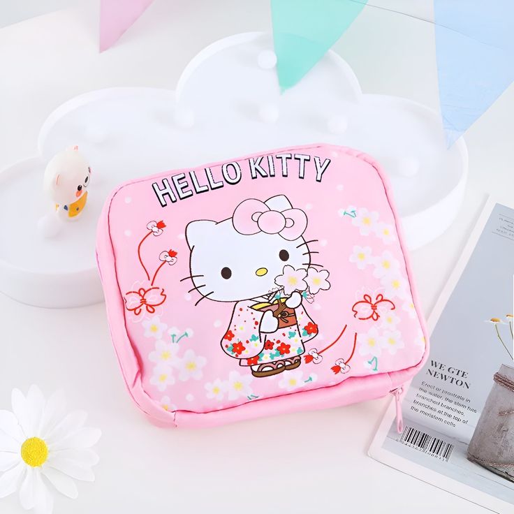 a hello kitty lunch box sitting on top of a table next to a flower pot