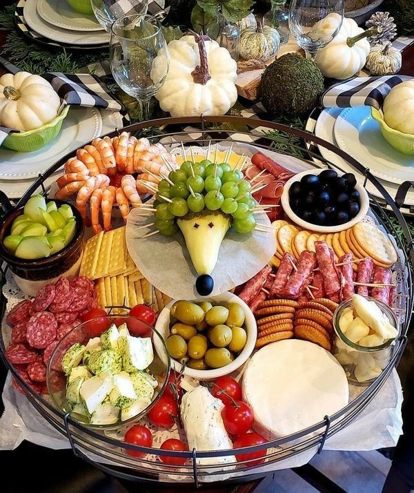 a platter filled with meats, cheeses and vegetables on top of a table