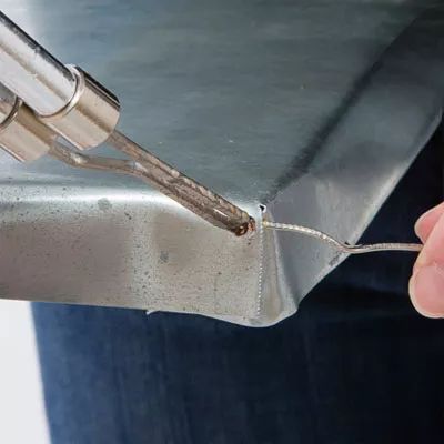 a person holding a piece of metal in their right hand and pulling it with the other end