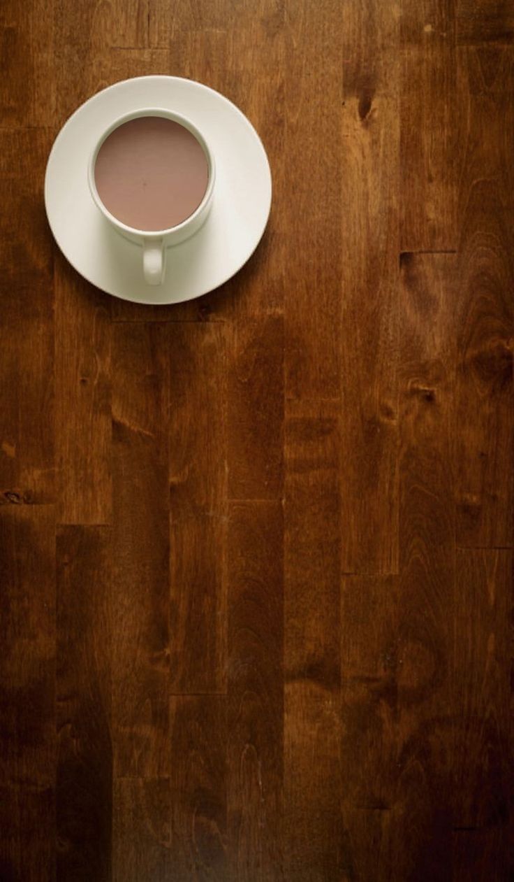 a cup of coffee sitting on top of a wooden table