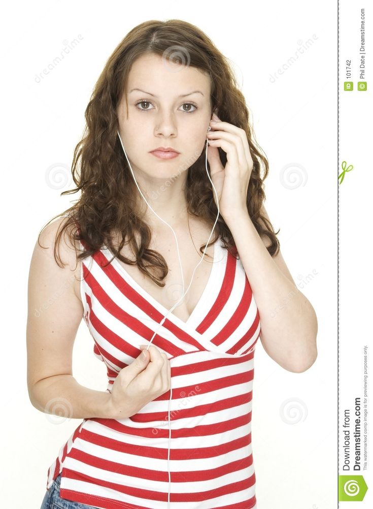 a young woman listening to music with headphones on her ears while standing against a white background