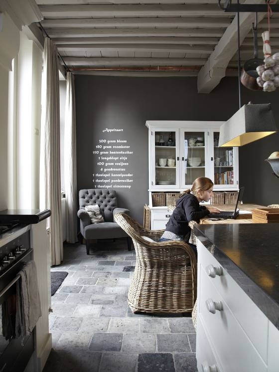 a young boy sitting on a chair in a kitchen next to a stove top oven