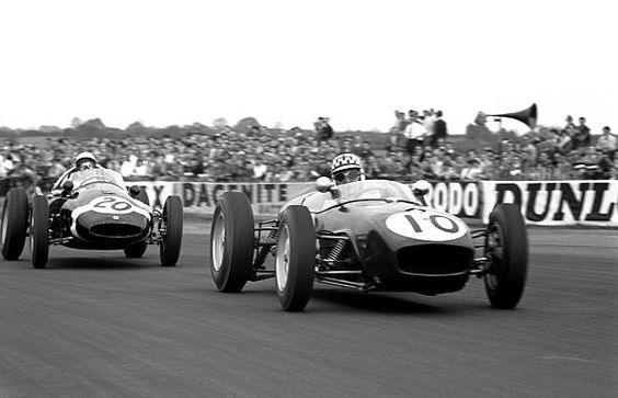 two race cars racing down the track in front of an audience