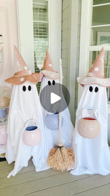 three white witches with pink hats on their heads and brooms in front of a house