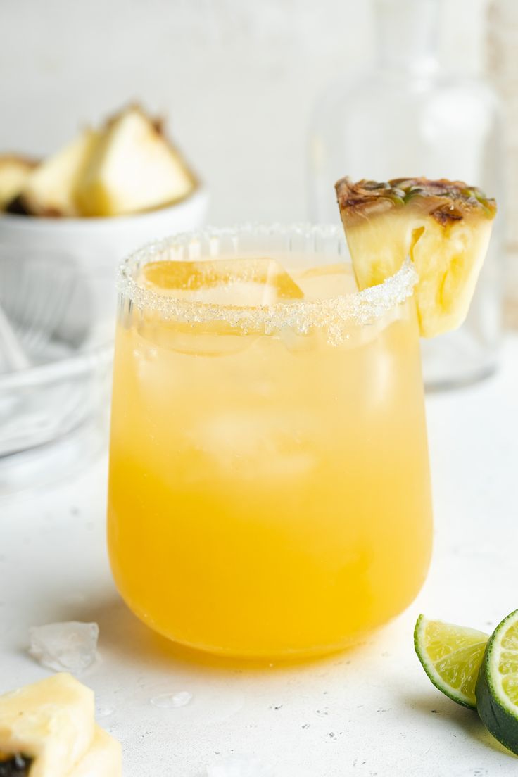 a close up of a drink in a glass with a slice of fruit on the rim