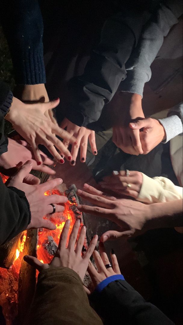 a group of people standing around each other with their hands on top of each other