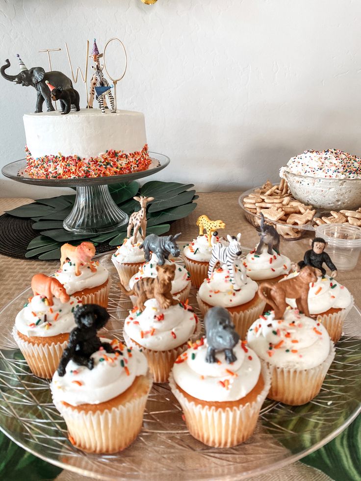 cupcakes with white frosting and small figurines sitting on top of them