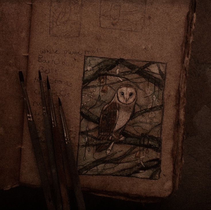 an owl sitting on top of a book next to some pencils and paintbrushes