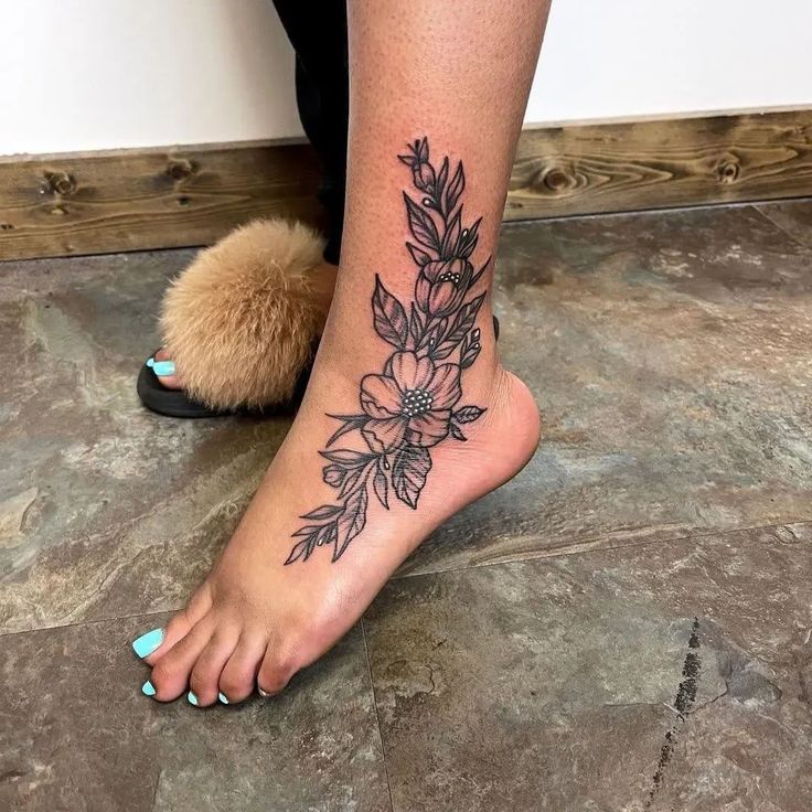 a woman's foot with a flower tattoo on it