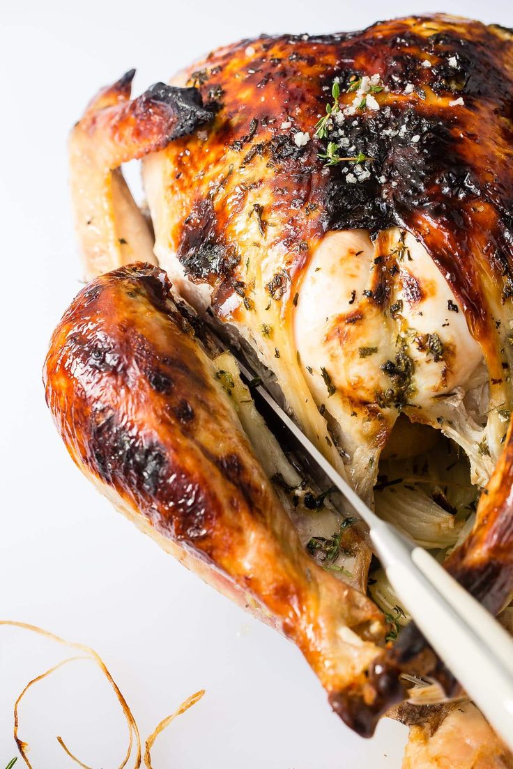 a whole chicken on a white plate with chopsticks