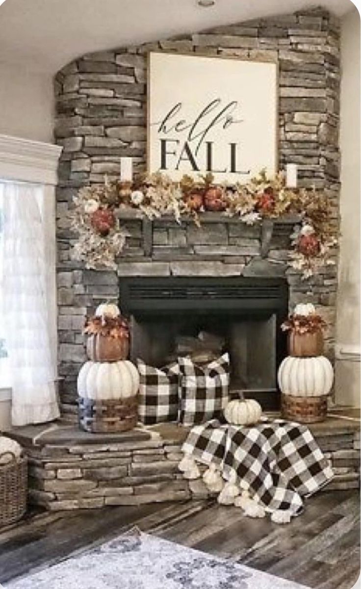 a living room filled with furniture and a fire place covered in fall decorations on top of a wooden floor