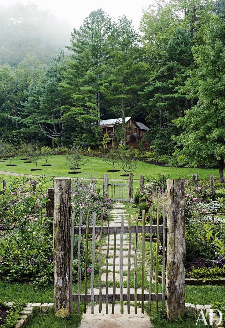 an open gate leading into a lush green yard