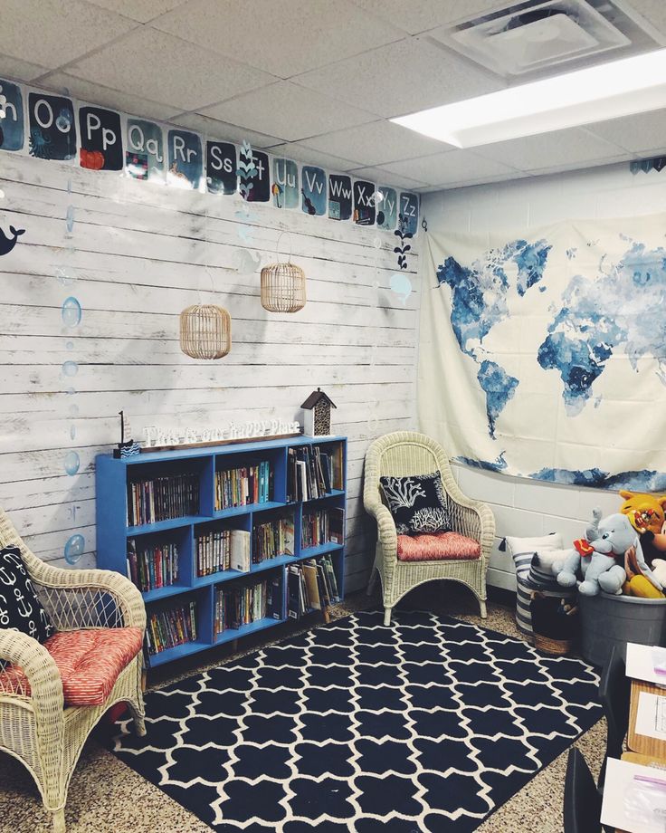 a child's room with two chairs, a book shelf and a map on the wall