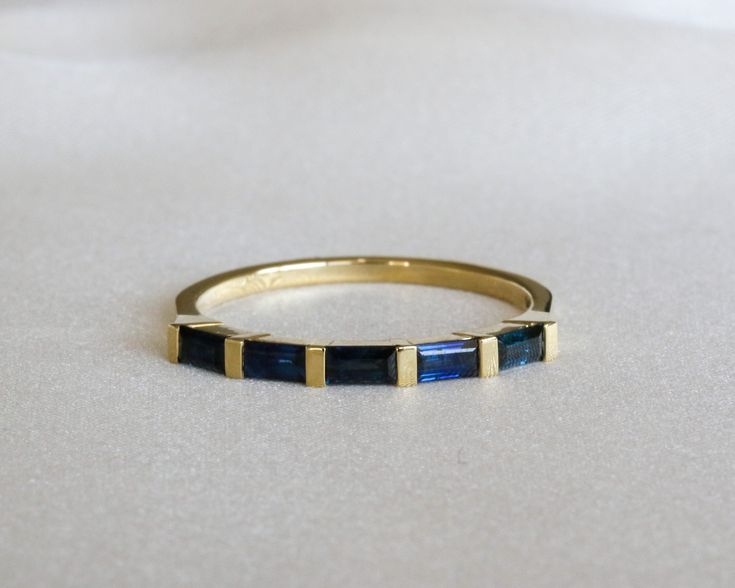 "Natural sapphire baguette eternity ring, five \\ seven stone ring made from 14K yellow gold.   A Unique minimalist ring design, the ring is set with with 5 baguette cut, blue sapphires.  Available also in other gold colors such as white gold or rose gold and also in 18K gold - please see all options and quoting in the drop down menu above. Ring description: * Dimensions: approx. 0.078\" / 2 mm. * Materiel: 14K gold. Stone: * 5 natural sapphires, baguette cut.  * TWC: approx. 0.75 CT  Variations Sapphire Baguette Band, Sapphire Channel Set Ring, Sapphire Baguette Ring, Baguette Eternity Ring, Sapphire Band Ring, Gem Tones, Sapphire Eternity Ring, Saphir Ring, Sapphire Wedding Band