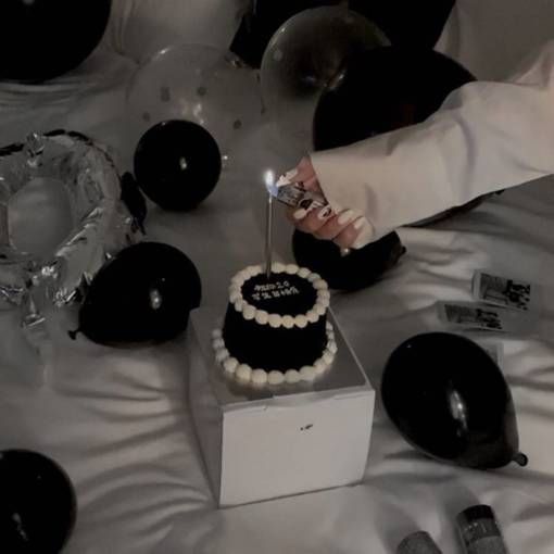 a person is cutting into a cake with a small candle on the table next to it