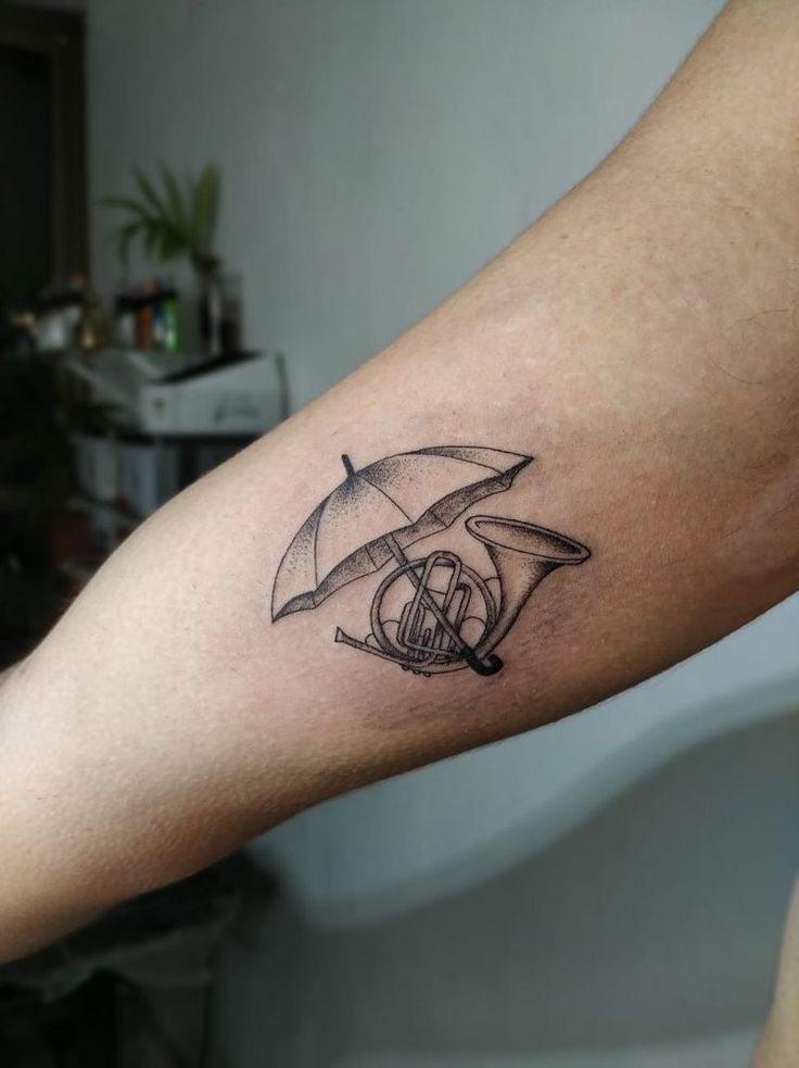 a person with a tattoo on their arm holding an umbrella