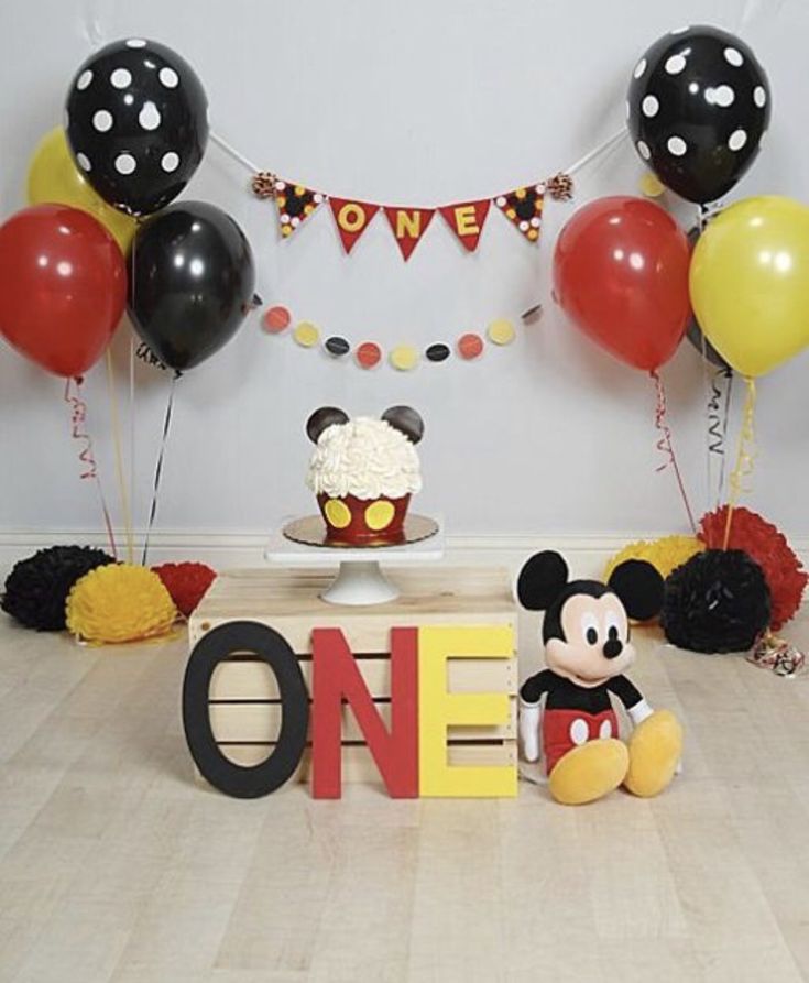 a mickey mouse birthday party with balloons and decorations