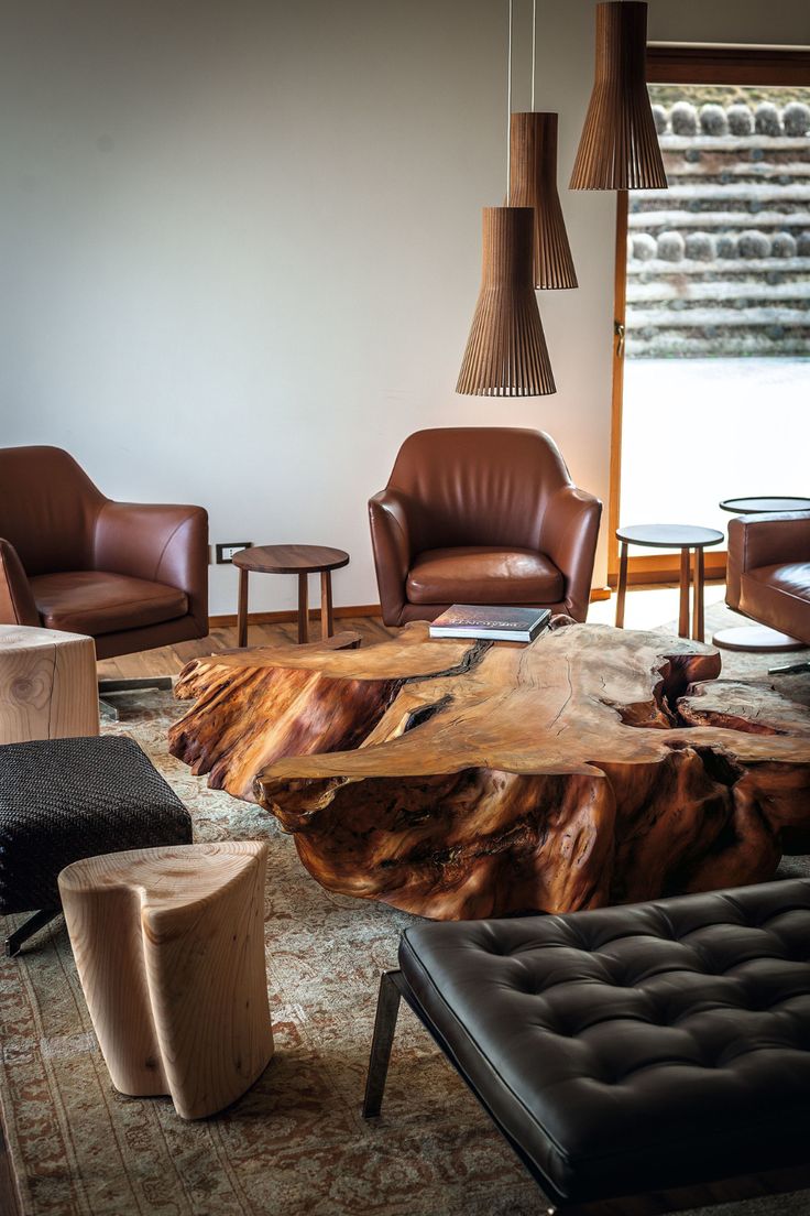 a living room filled with lots of furniture and wooden table in the middle of it