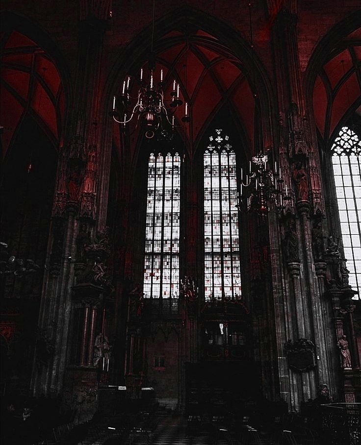 the interior of an old church with stained glass windows and chandelier hanging from the ceiling