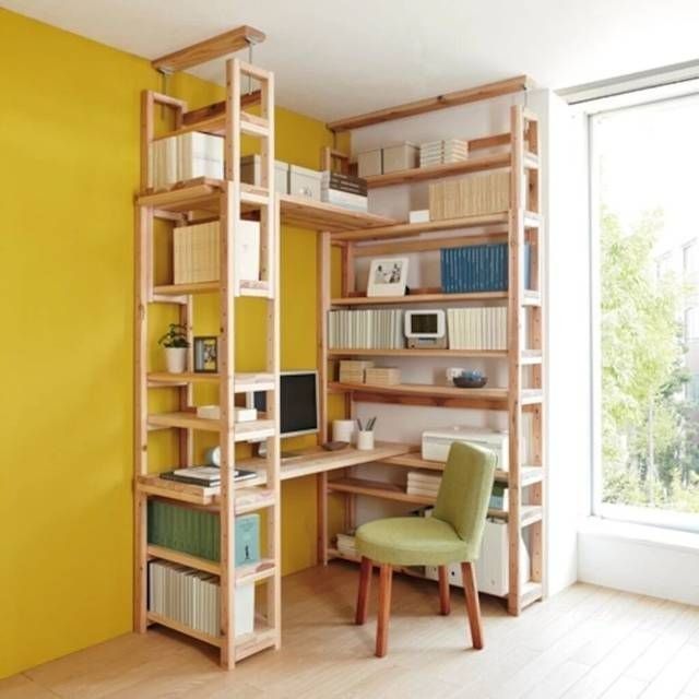 a room with yellow walls and wooden shelves filled with books, computers and other items