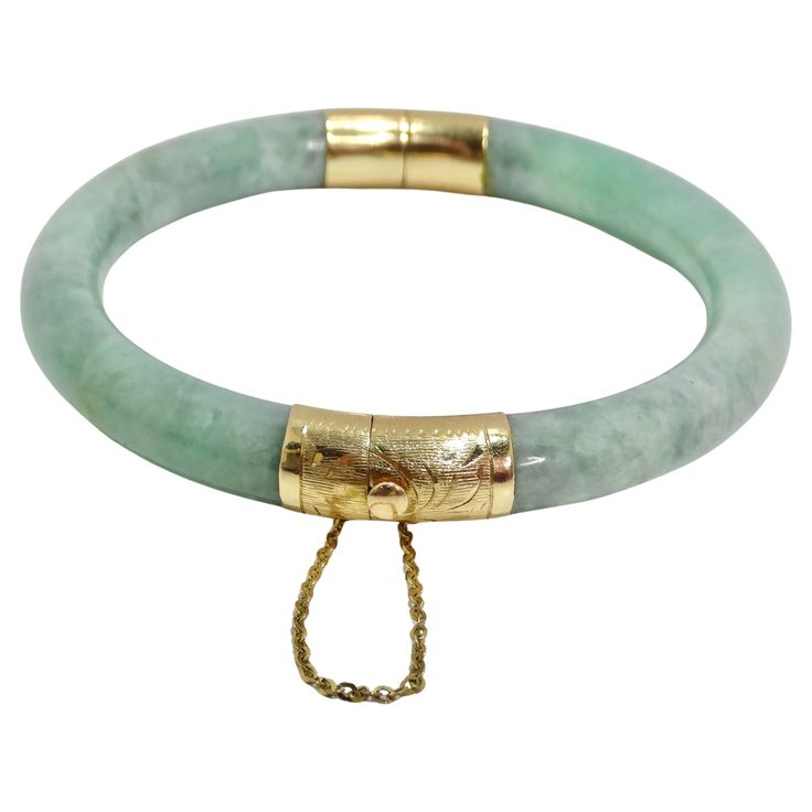 Indulge in timeless elegance with the 14K Gold Jade Jadeite Hinged Bangle Bracelet, a stunning piece that seamlessly blends precious materials with intricate craftsmanship. This estate jadeite bangle features a captivating natural light green moss/mint color, exuding a sense of luxury and sophistication. The 14k yellow gold clasp and hinge, adorned with Asian decorative etching on the ends, add a touch of cultural richness to the bracelet. The safety chain ensures both security and style, providing an extra layer of assurance for this exquisite piece. Whether worn on its own as a statement accessory or paired with other fine jewelry, this bracelet is a testament to refined taste and enduring beauty. The 14K Gold Jade Jadeite Hinged Bangle Bracelet is not just a piece of jewelry; it's a tim Affordable Jade Bangle Jewelry, Jade Accessories, Green Jade Bracelet, Tanzanite Bracelet, Jewelry Accessories Ideas, Jade Bangle, Buckle Bracelet, Safety Chain, Jade Bracelet