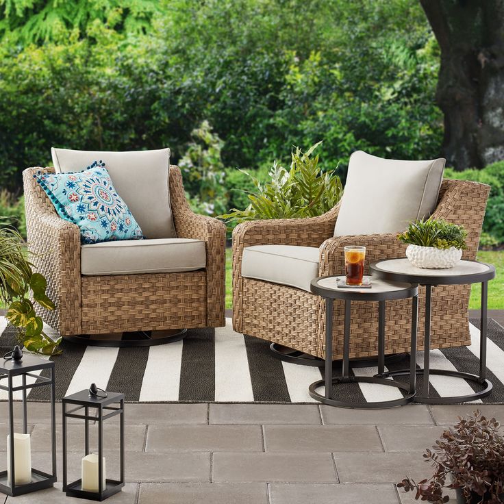 two wicker chairs sitting on top of a patio next to a table with candles