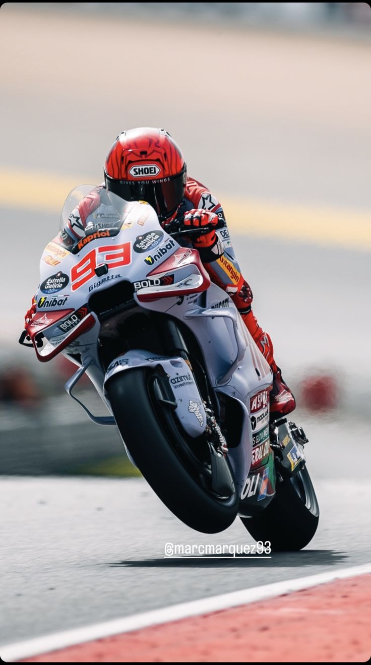 a man riding on the back of a motorcycle down a race track