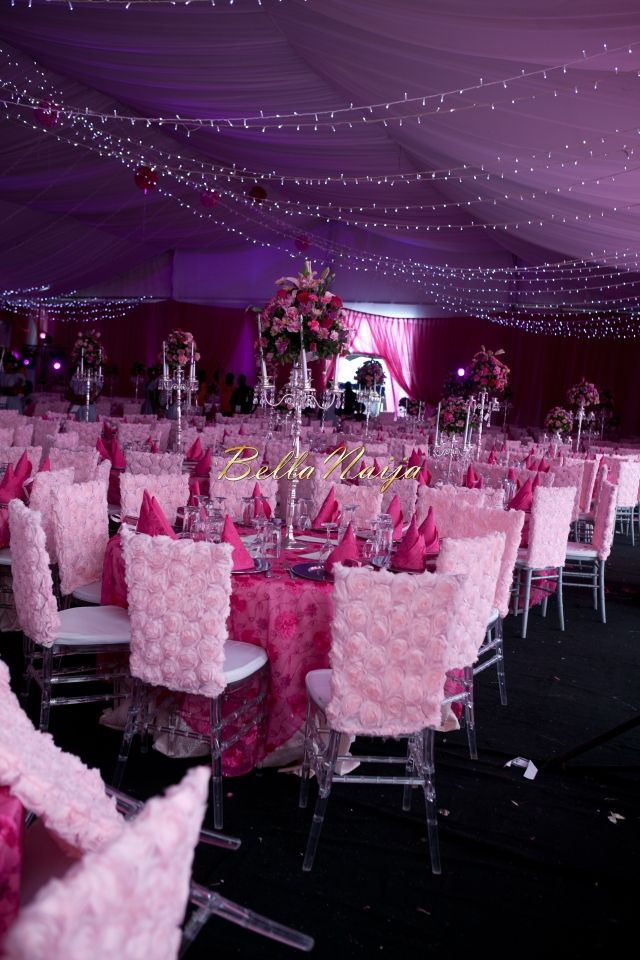 tables and chairs are set up for a wedding reception with pink flowers on them, surrounded by fairy lights