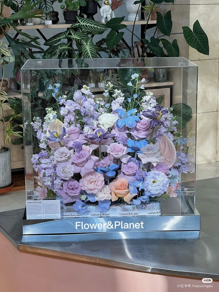 a flower and plant display in a clear box