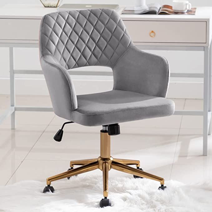 a black office chair sitting on top of a white rug in front of a desk