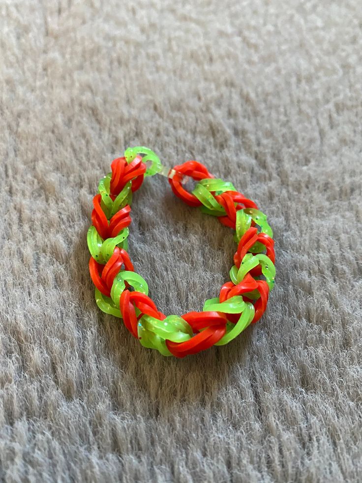 a red and green bracelet sitting on top of a carpet