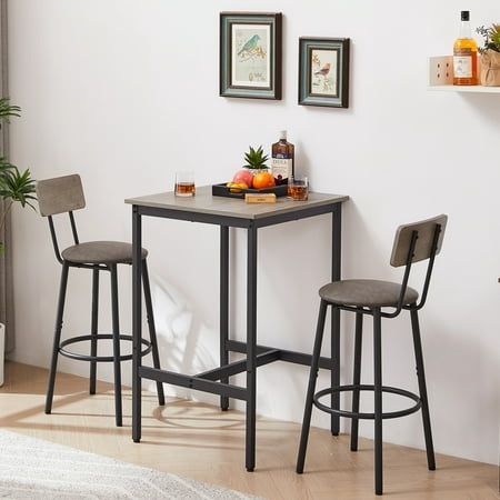 a small table with two stools next to it in a living room area,