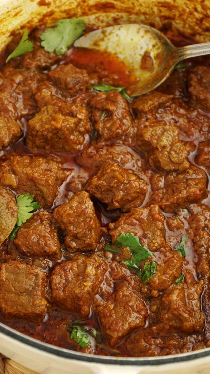 a pot filled with meat and garnished with cilantro