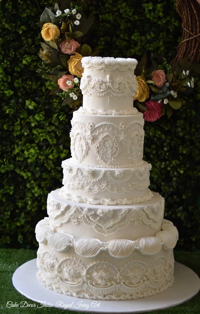 a large white wedding cake sitting on top of a plate