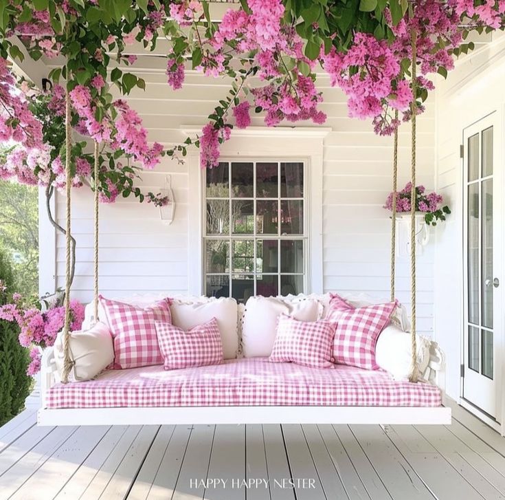 a porch swing with pink flowers on it