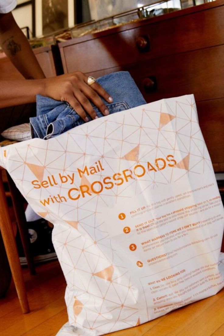 hand placing a pair of jeans into a Crossroads Sell By Mail bag Selling Used Clothes, Spring Clean, 10 Year Anniversary, Too Busy, Love Clothing, Spring Cleaning, How To Get Money, Easy Step, Paper Shopping Bag