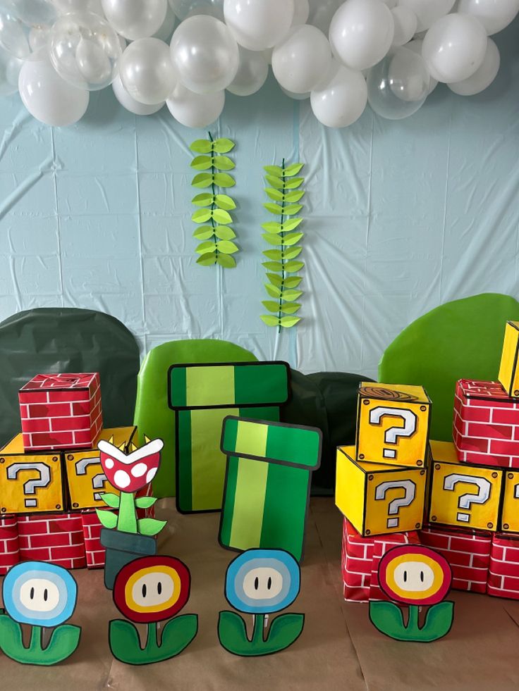 a bunch of paper toys sitting on top of a table next to balloons and streamers